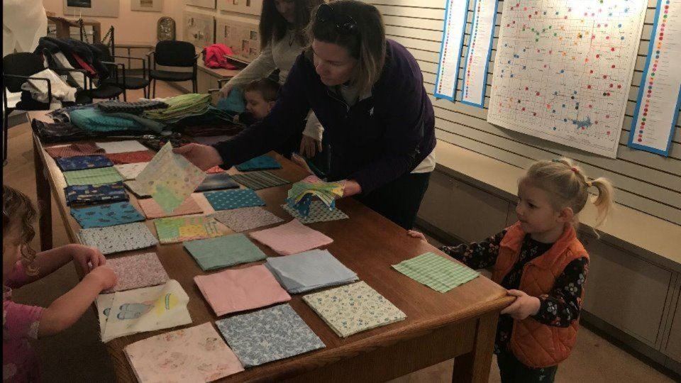 Little girl picking out quilt blocks